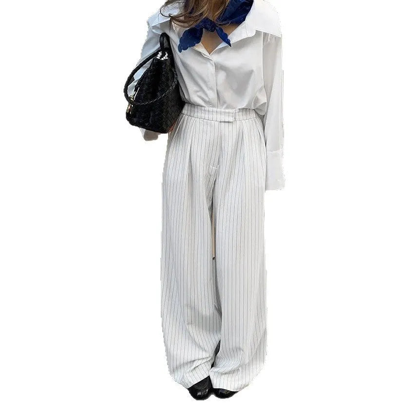 White striped wide-leg women's trousers with a front zipper on a hanger.