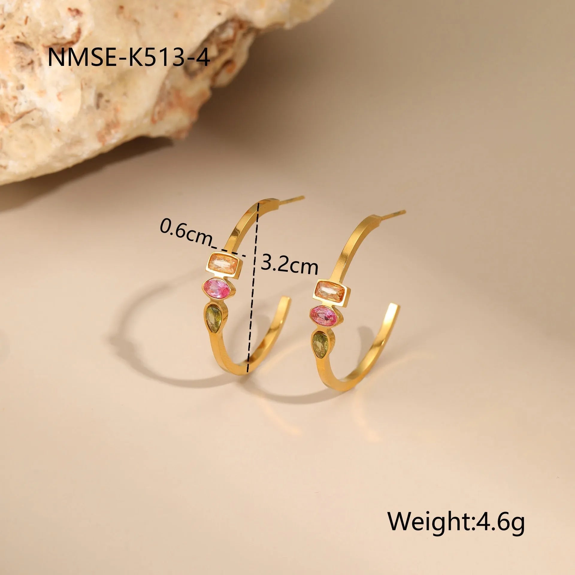Geometric gold plated jewellery set with colour zircon necklace, ring, and earrings on a white background.