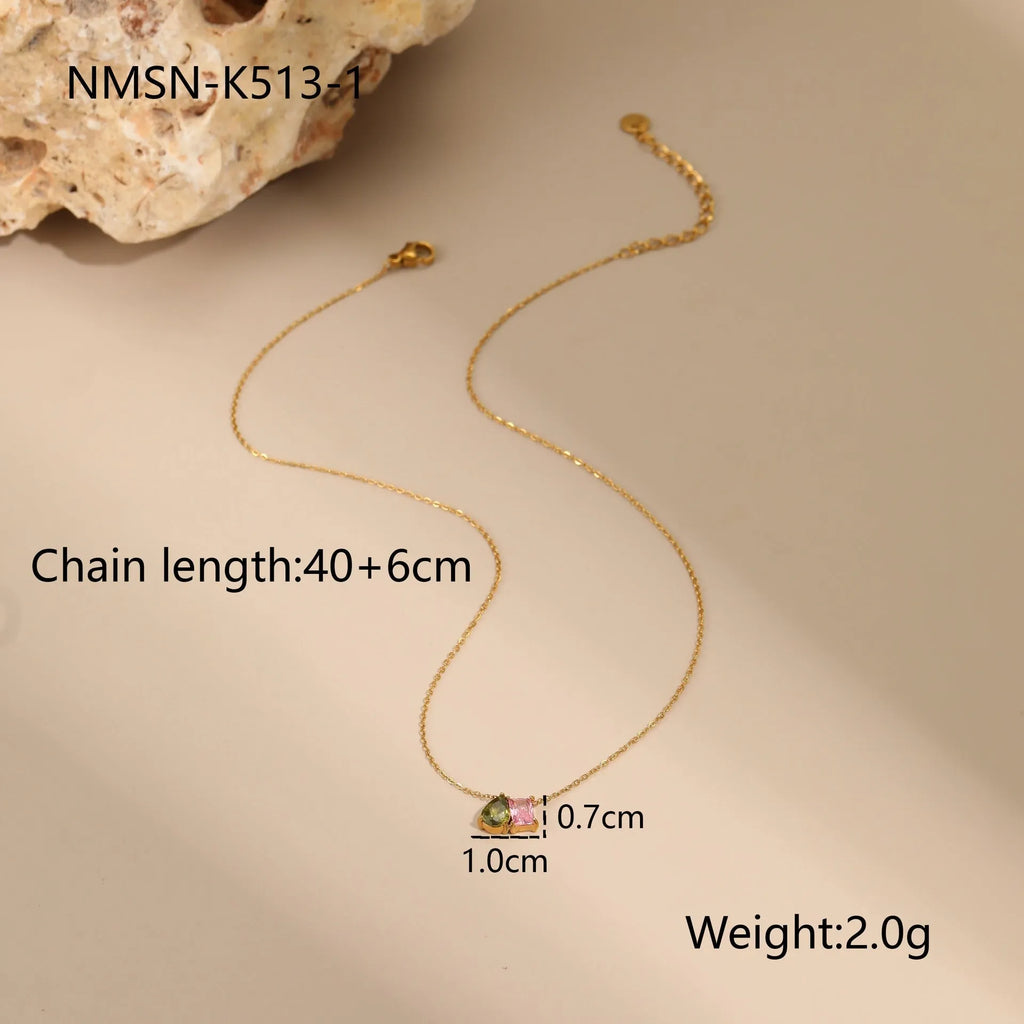 Geometric gold plated jewellery set with colour zircon necklace, ring, and earrings on a white background.
