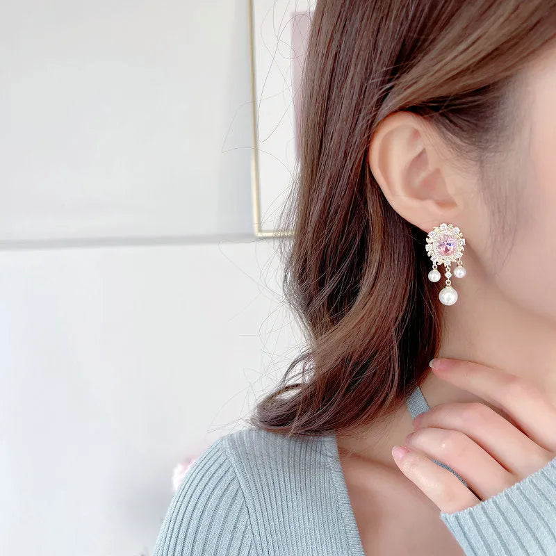 Oval-shaped copper earrings with zircon-inlaid pearls and long decorative tassels in light purple.