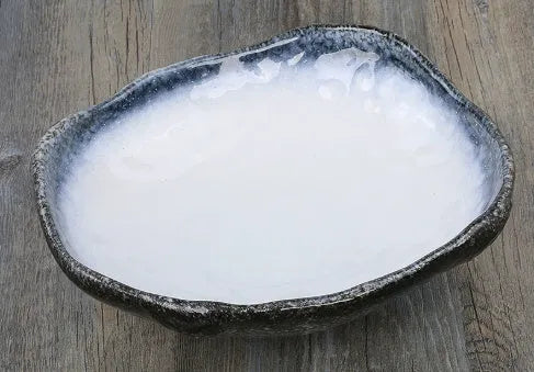 Japanese-style ceramic sashimi bowl with irregular shape and floral decoration