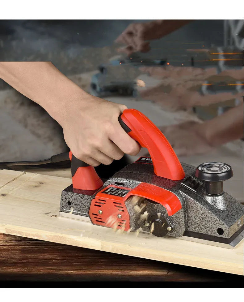 Red desktop electric wood planer with aluminium housing showing 82mm cutting width