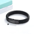 Black stainless steel memorial bracelet with a woven leather compartment for ashes and an engraved plate.
