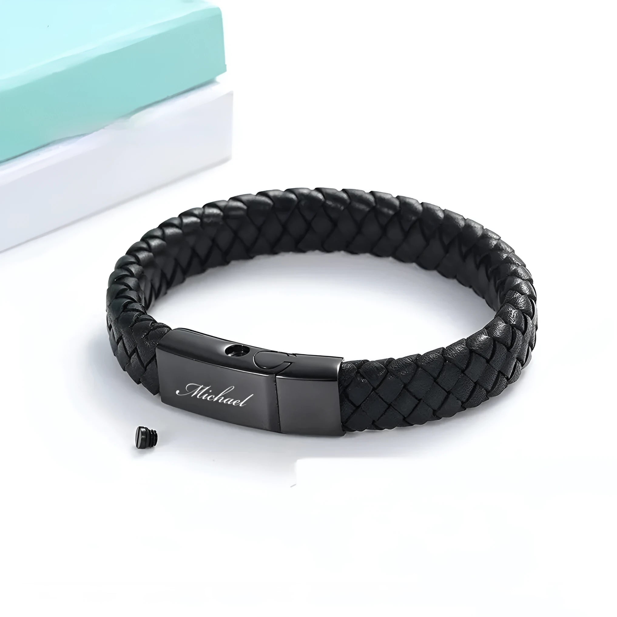 Black stainless steel memorial bracelet with a woven leather compartment for ashes and an engraved plate.