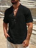 Man wearing a solid colour short-sleeve shirt with a stand collar in a casual setting.