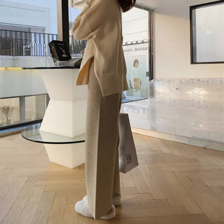 Women's cream white high waist wide-leg knitted trousers with a long mopping hem and elastic waistband.