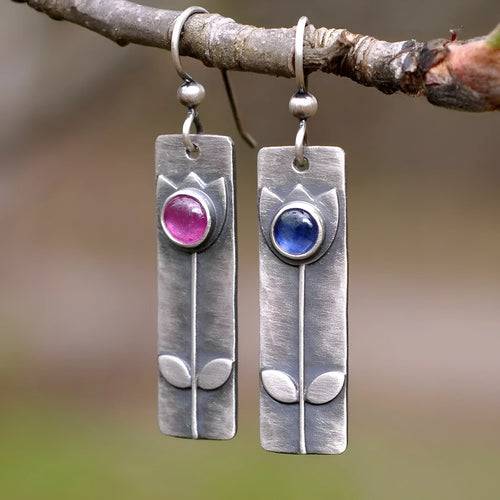 A pair of red sapphire earrings with an antique finish and geometric design.