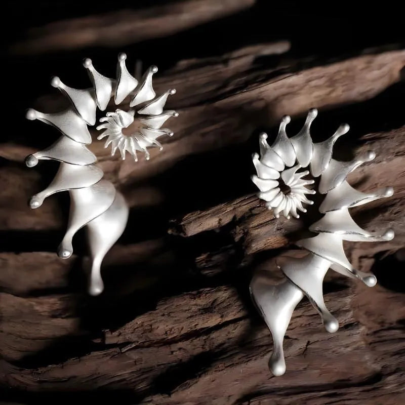 Exaggerated three-dimensional conch shell stud earrings with a matte finish in an irregular abstract design.