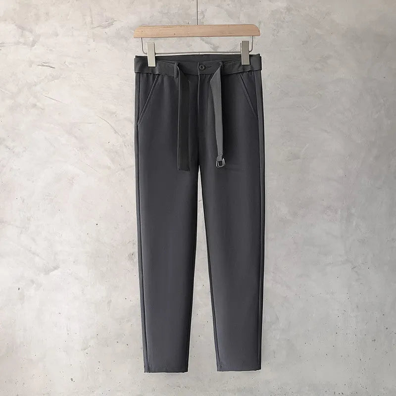 Boy wearing slim straight wool trousers in a neutral colour, showcasing the tapered fit and straight leg opening.