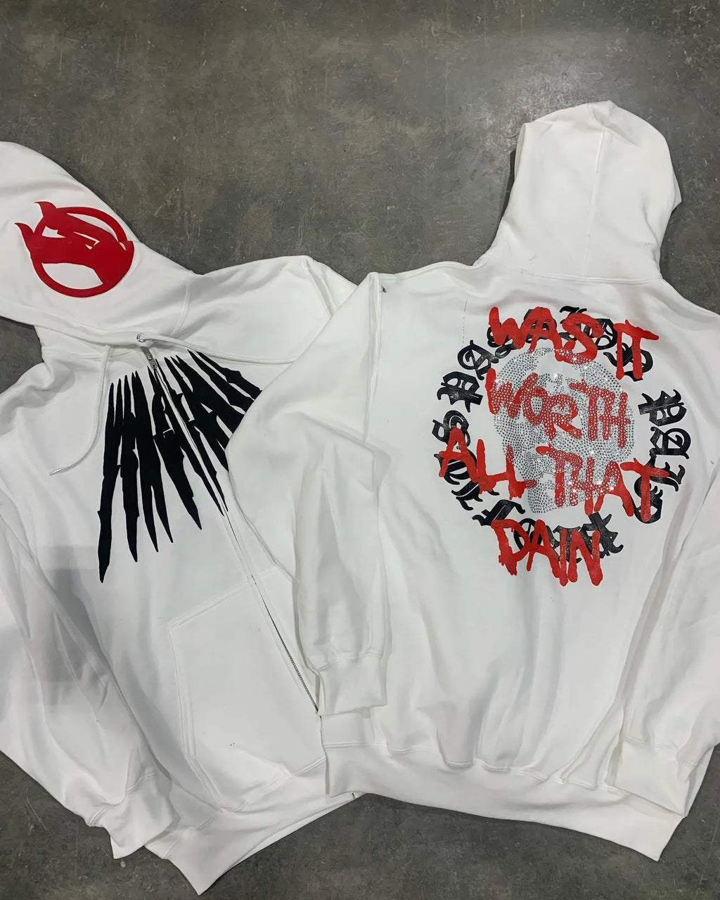 Black loose hooded cardigan sweatshirt with white skull and rhinestone print, long sleeves.