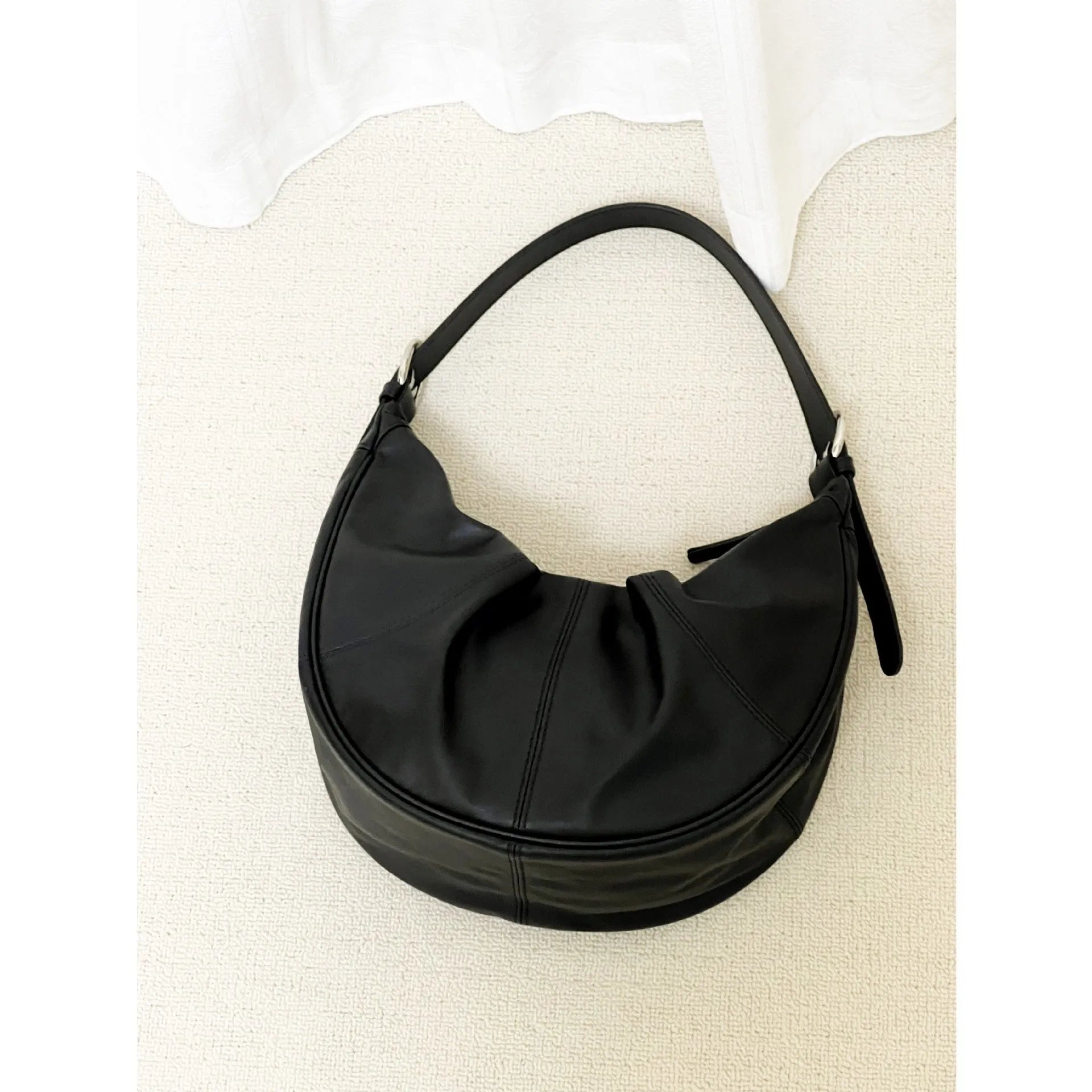 Women's soft cowhide leather dumpling-shaped shoulder bag in black with double straps and sandwich pockets.