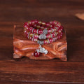 Natural watermelon crystal bracelet with a handmade Chinese knot closure, showing geometric beads.