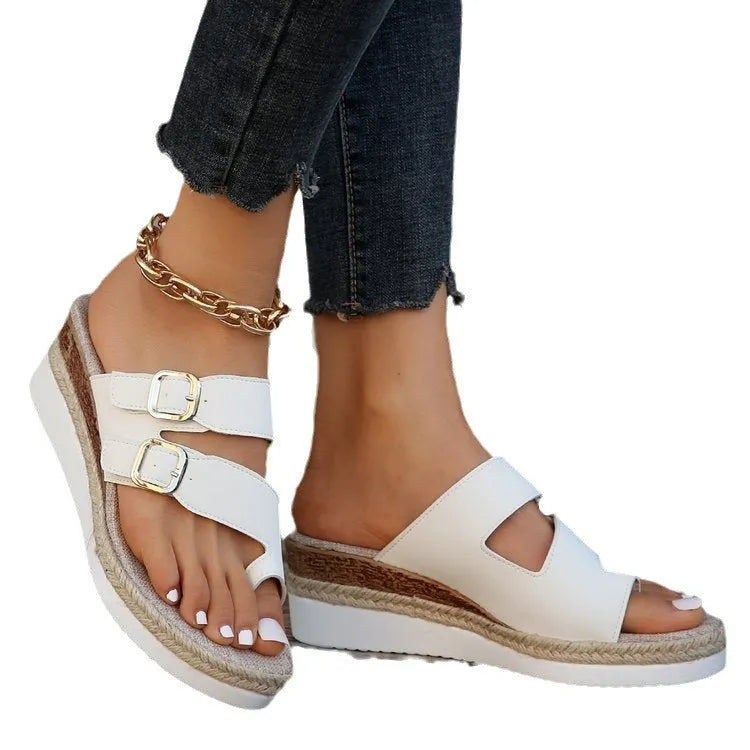 White wedge heel sandals with woven patent leather upper and peep toe design on neutral background