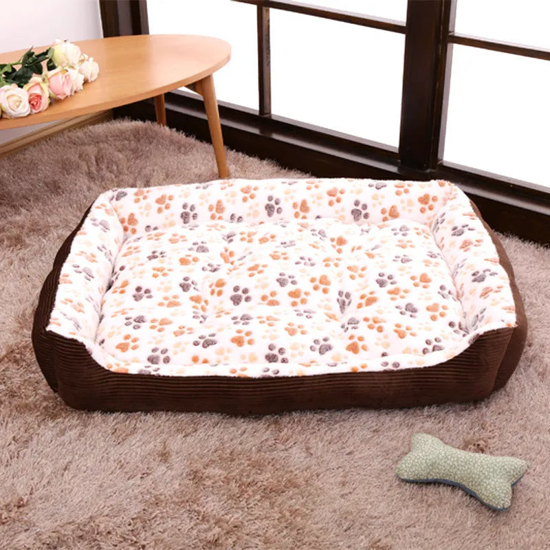Beige plush sofa-style pet bed for small dogs with a raised bolster edge, shown in a home setting.