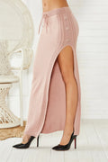 Slim-fit mid-length acrylic skirt with split design and strap detailing in black, pink, or grey colours