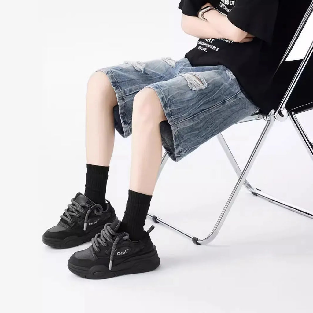 Loose washed blue denim shorts with a ripped knee detail on a mannequin, showing the retro fit.