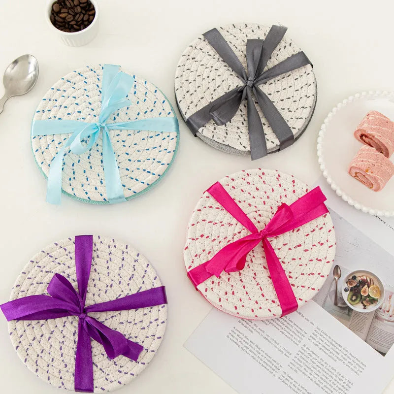 Set of three round grey cotton cord coasters on a wooden table, each 18cm in diameter.
