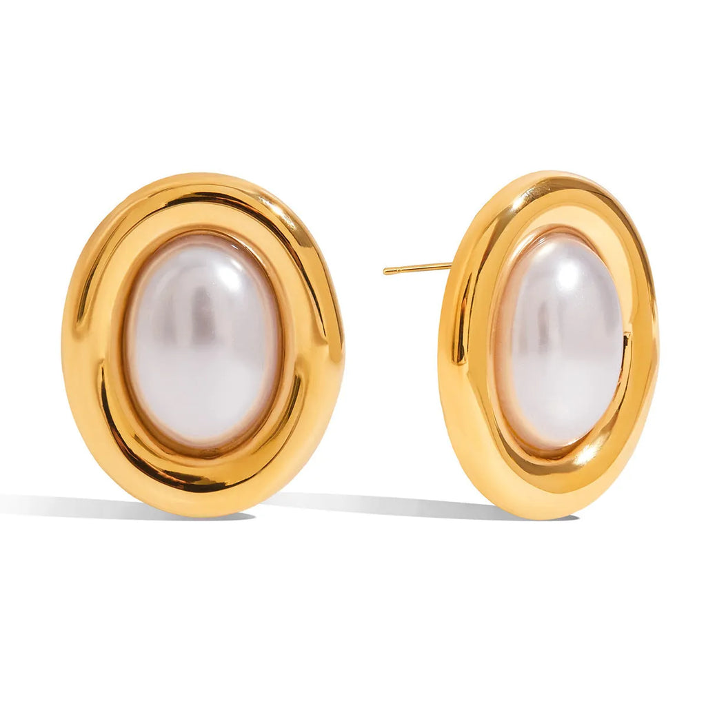 Small gold-tone stainless steel stud earrings with a white pearl accent on a grey background.