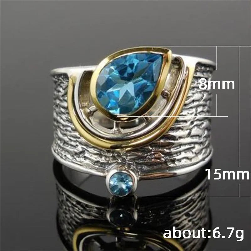 Blue zircon drop shape ring with Chinese style inlaid design on alloy band.