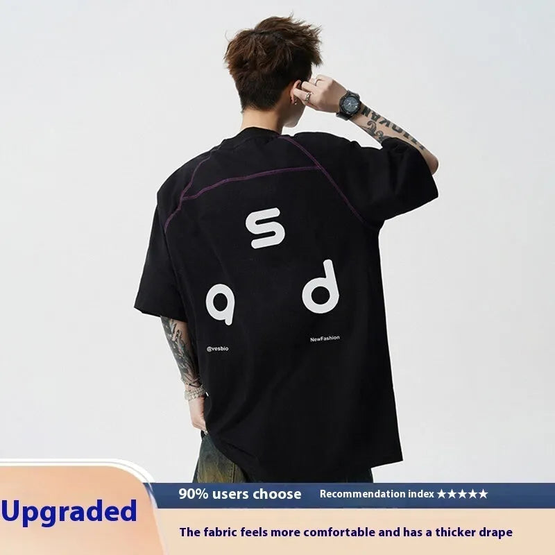 A loose-fitting black cotton short-sleeve T-shirt with a round neck on a hanger.