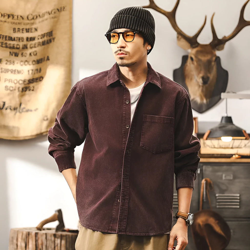 Man wearing a loose-fit red corduroy long-sleeved shirt jacket.