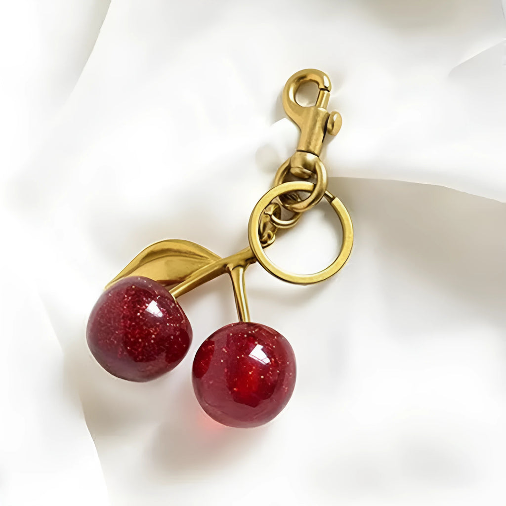 Red zinc alloy three-dimensional cherry pendant charm for key rings and bags.