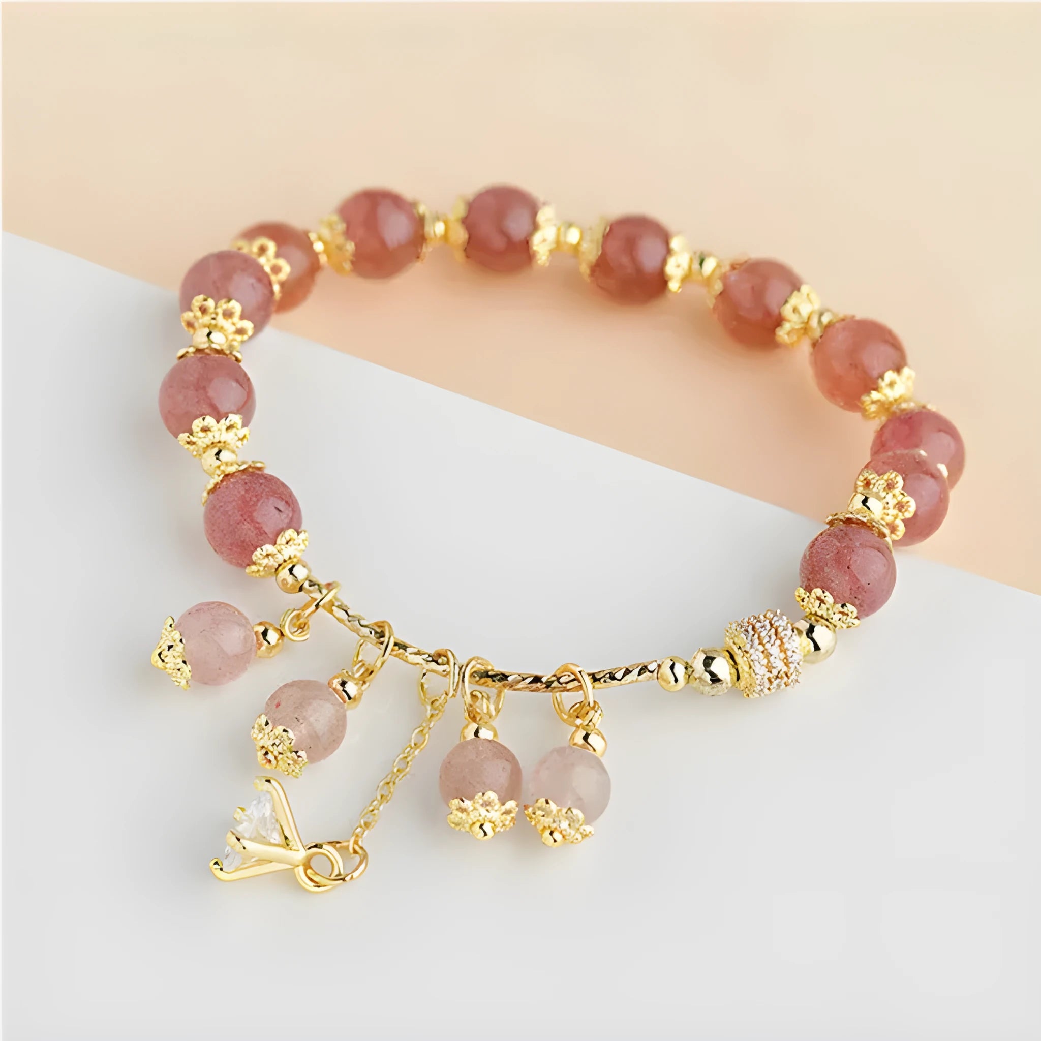 Women's pink strawberry quartz crystal bracelet with heart-shaped charms and pearl decorative elements