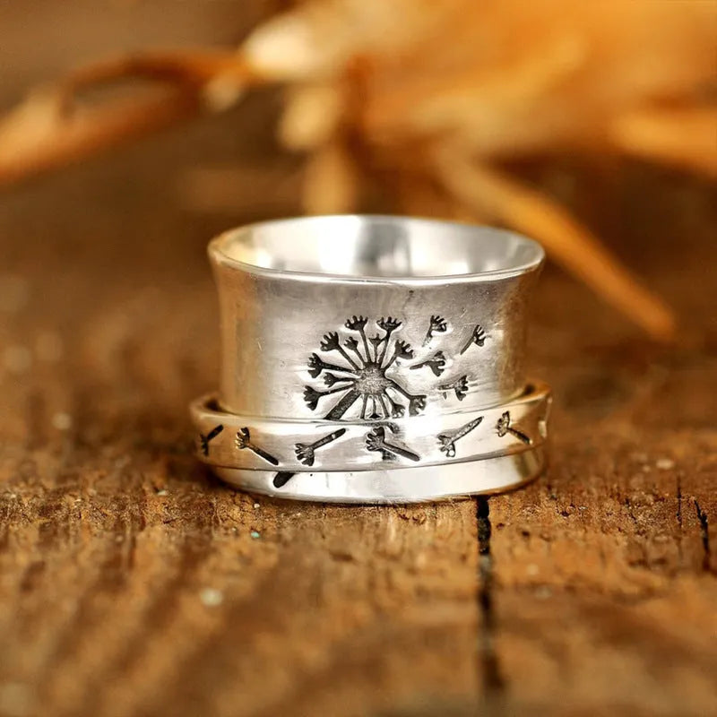 Silver tone floral fashion ring with rotatable flower element on alloy band