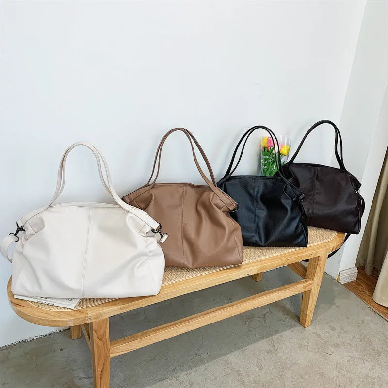 Large soft surface black messenger bag with a shoulder strap and zipper opening.