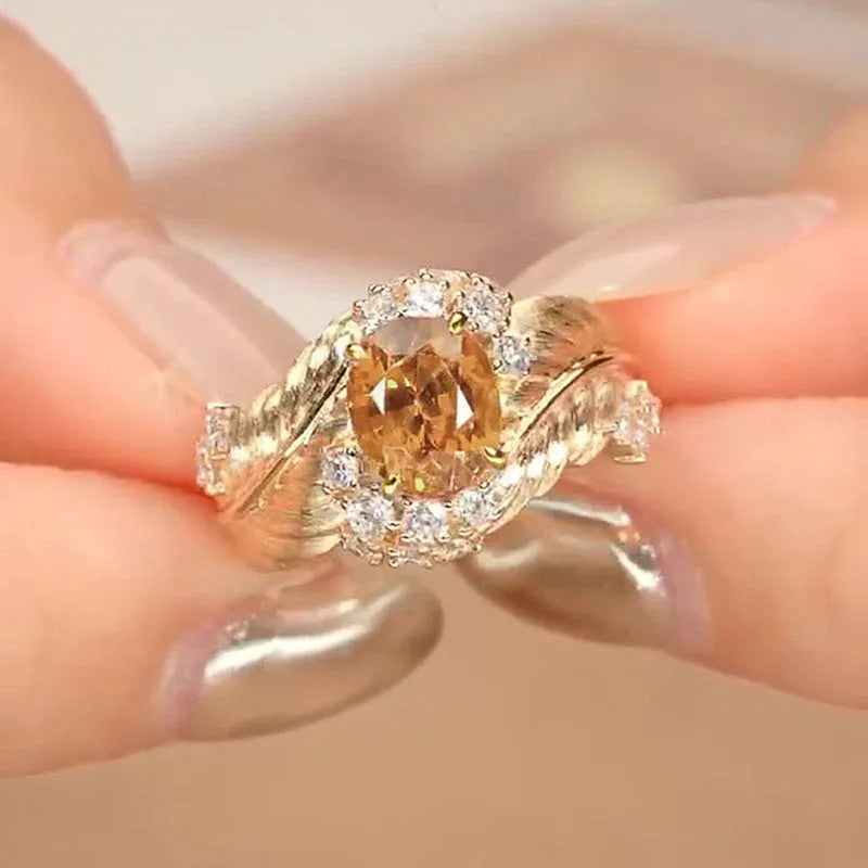 Gold-coloured embossed feather ring with geometric pattern and yellow zircon stone
