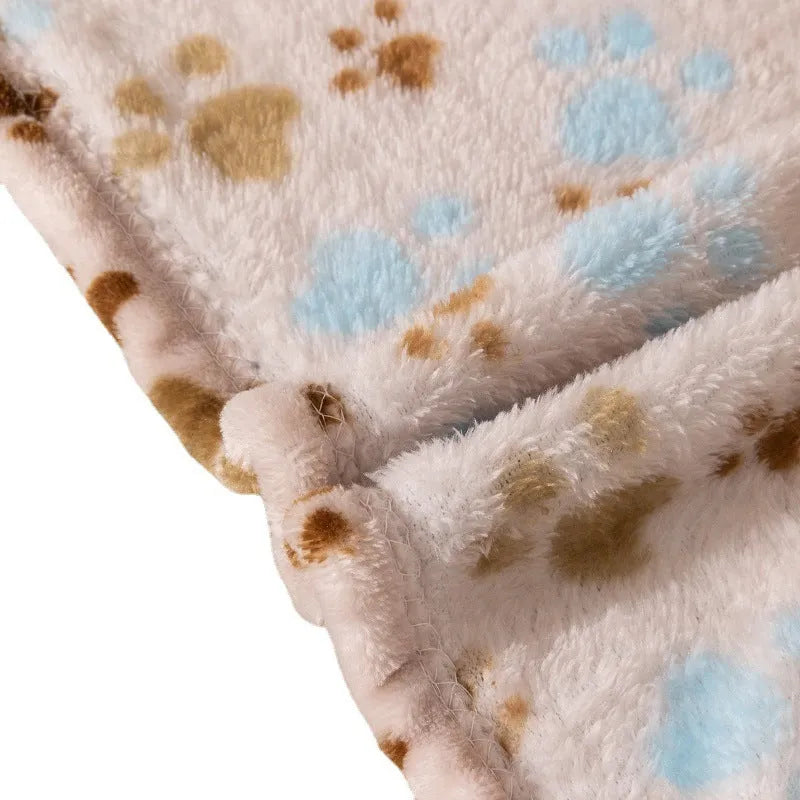 Blue cartoon dog paw patterned flannel pet blanket laid flat, showing its size.