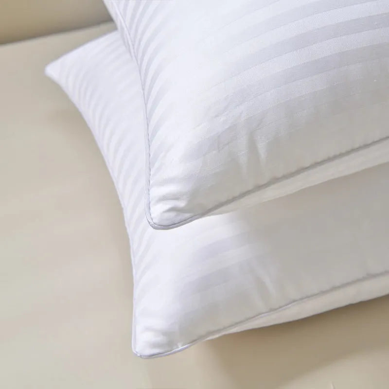 White hotel cotton satin stripe pillow with feather and cotton filling on a bed.