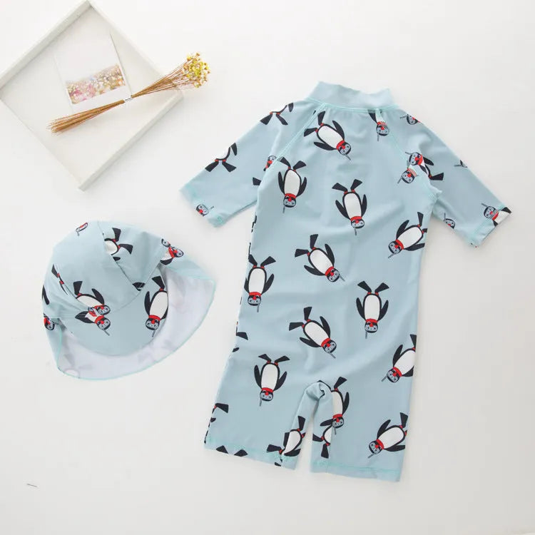 Blue boys two-piece penguin swimsuit with long sleeves and a matching swim cap.