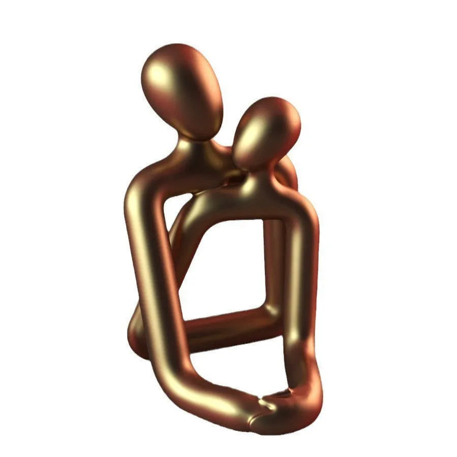 Modern resin statue of an embracing couple in milky white or gold finish on a wooden surface.