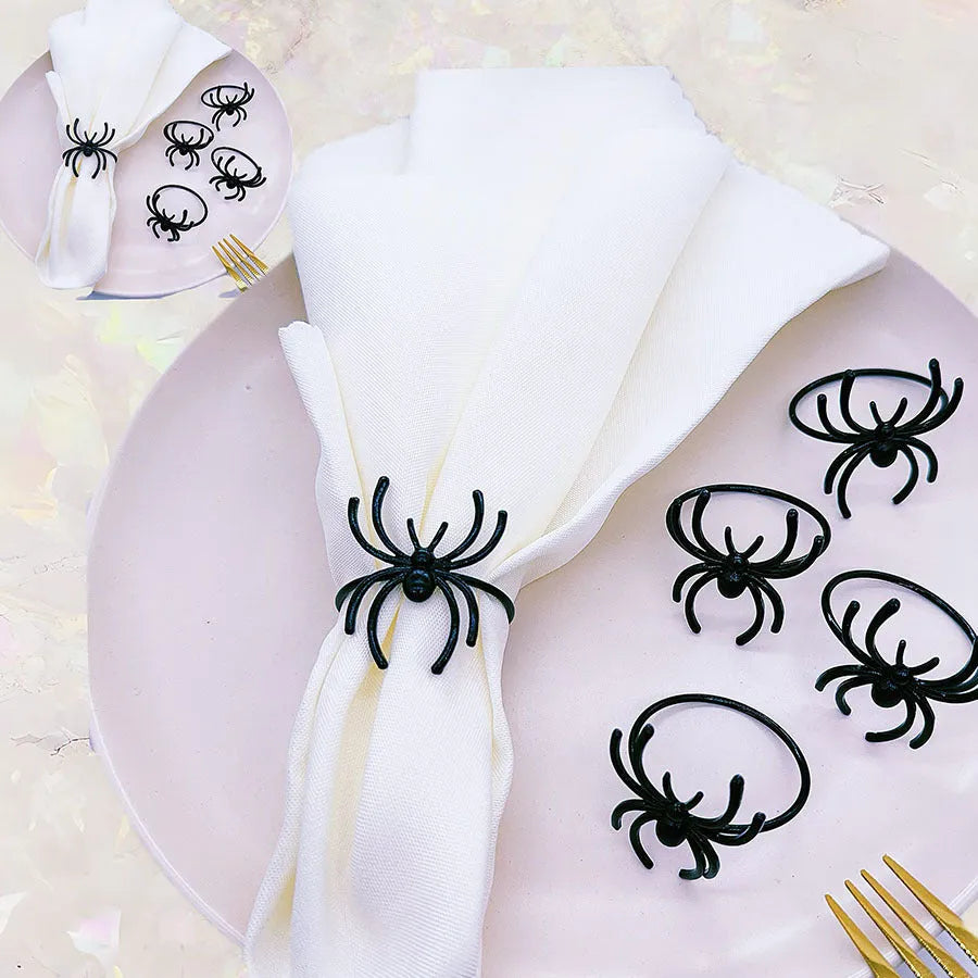 Set of six black alloy napkin rings with spider design for Halloween table decoration.